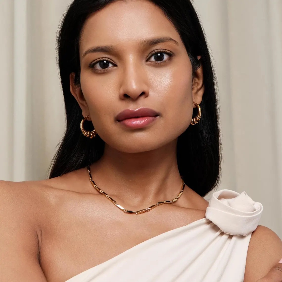 Detail lesklého 18K pozlacení náušnic ELENYS Essence Hoops Gold